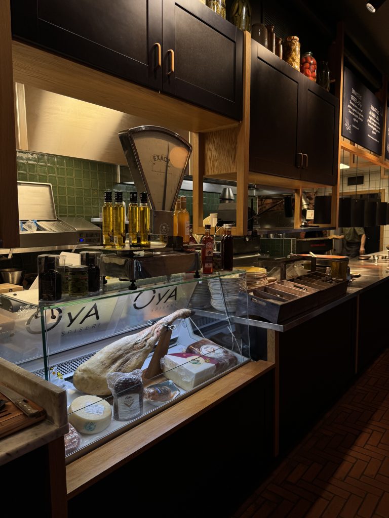 Øya Spiseri Porsgrunn – delikatessemonter med spekkskinke, italienske oster og premium oljer foran det åpne kjøkkenet.