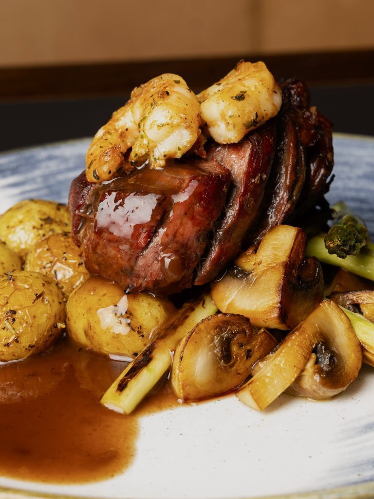 Indrefilet av okse med scampi, mare e monti. Servert med ristet sopp, asperges, spicy rødvinssaus og amadinepoteter